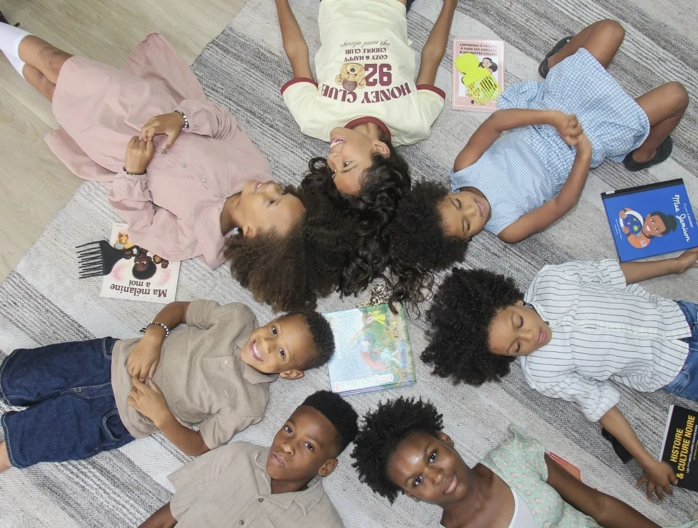 Curly hair types in children: kids with curly and coily hair lying in a circle with books